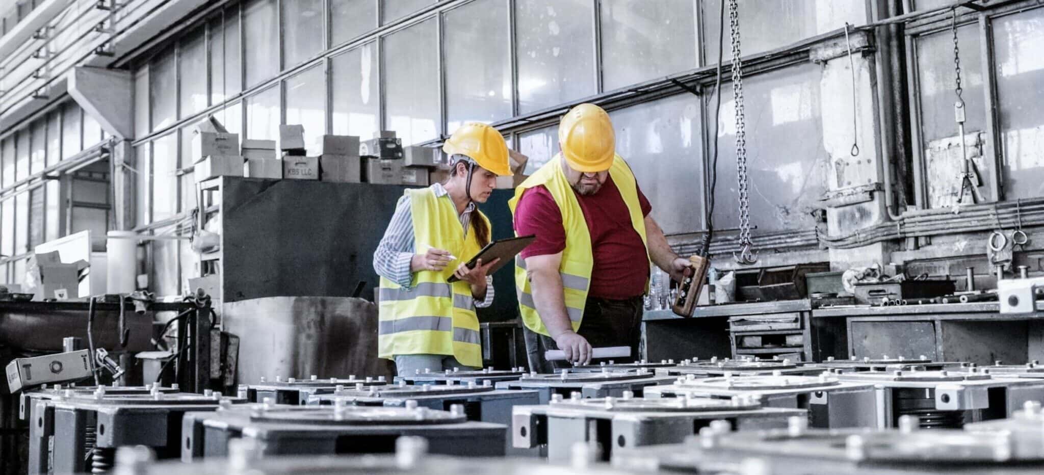 Engineers reviewing operational data on a factory floor