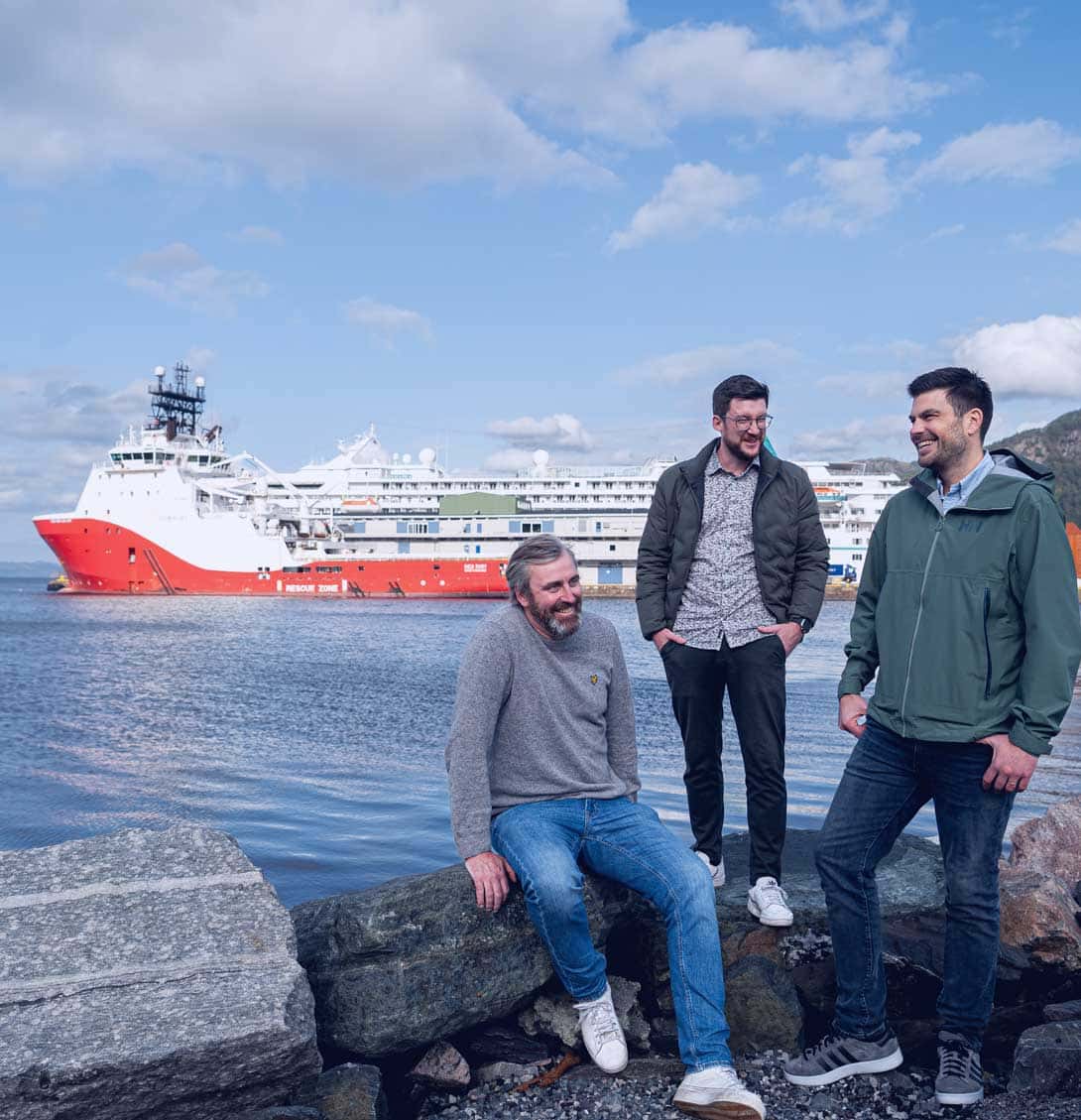 The Nortech AI team on the waterfront, with offshore and expedition vessels behind them.